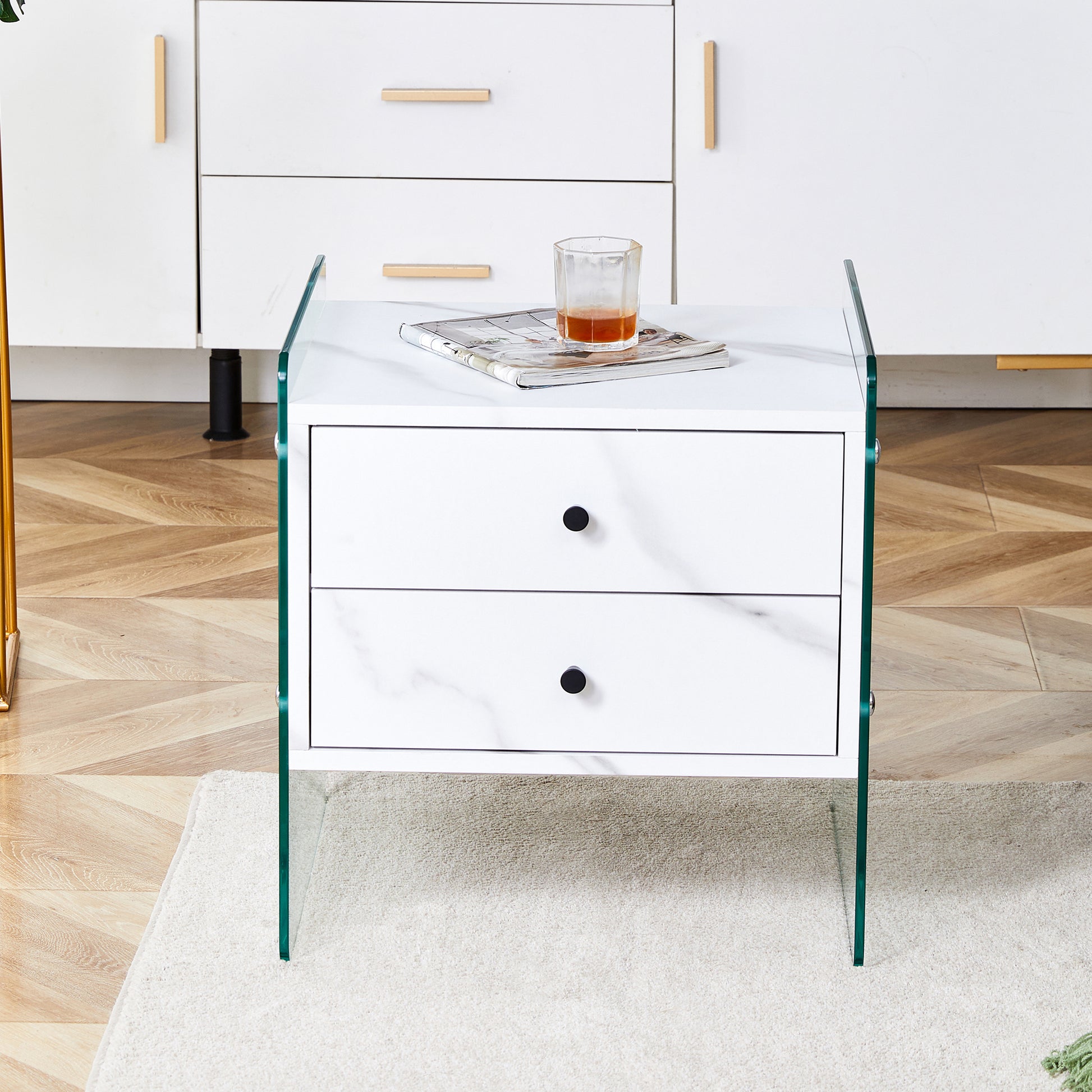 Double Drawer Bedside Table. The Board Surface Is Mdf Sticker, And Both Sides Are Transparent Tempered Glass. The Design Is Simple And Elegant, With Excellent Storage Functions. White Mdf