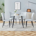 Table And Chair Set. Large Modern White Imitation Marble Patterned Round Table With Black Metal Legs. Nice Minimalism, Comfortable Seats And Black Metal Legs. White Gray Seats 4 Glass Metal